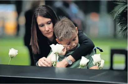  ?? Reuters ?? A woman, along with a child, listens to the readings of victims’ names, during ceremonies marking the 17th anniversar­y of the September 11, 2001, attacks on the World Trade Centre, at the National 9/11 Memorial and Museum in New York. —