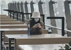  ??  ?? 0 A woman wears a mask at a railway station in Hong Kong