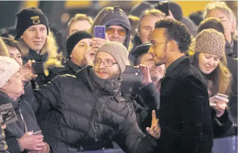  ??  ?? Formula One world champion Lewis Hamilton, right, poses for a photograph with a fan in St Petersburg.