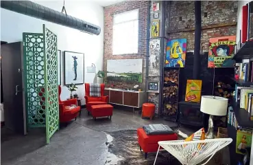  ??  ?? Mid-century modern furniture and art pepper the colourful space in Walker’s industrial-themed home.