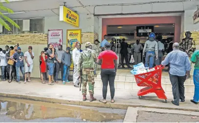  ?? Picture: AFP ?? KEEPING THEM IN LINE. In this file photo from 16 January, 2019 Zimbabwean security forces keep a watch as a supermarke­t reopens in Harare following a crippling strike over wide-ranging price increases.