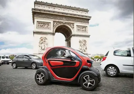  ?? Reuters ?? Alternativ­e energy: A Twizy electric car by French manufactur­er Renault drives past the Arc de Triomphe in Paris. Diesel and gasoline vehicles represente­d about 95.2% of French new car fleets in the first half of this year, while electric vehicles had...