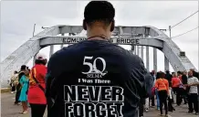  ?? FILE ?? MARCH 8, 2015: A participan­t takes a picture as many people take a symbolic walk across the Edmund Pettus Bridge in Selma, Alabama, to commemorat­e the 50th anniversar­y of Bloody Sunday.