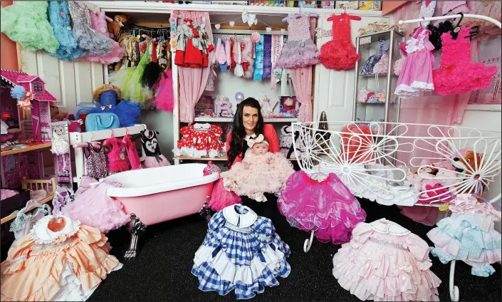  ??  ?? No expense spared: Witney Rowland with five-month-old Romany Rose and just some of the little girl’s belongings, including her £2,000 crib, £400 bath and an array of dresses