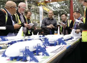  ?? (Jason Redmond/Reuters) ?? JASON CLARK (center), the vice president of Boeing 777 and 777X operations, points to a model during a media tour of the 777 Wing Horizontal Build Line at Boeing’s production facility in Everett, Washington, on June 1.