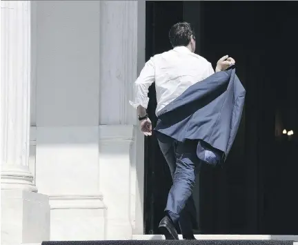  ?? LOUISA GOULIAMAKI/AFP/GETTY IMAGES ?? Greek Prime Minister Alexis Tsipras arrives at his Athens office, Monday. If he is to push the EU deal through the Greek parliament, Tsipras will have to disown some of his closest friends and allies in the radical Syriza party, writes Matthew Fisher.