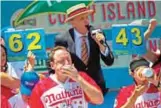  ??  ?? Joey Chestnut, left, and Matt Stonie compete in the Nathan's Famous Hotdog eating contest Tuesday in Brooklyn, New York. — AP photos