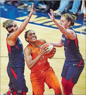  ?? SEAN D. ELLIOT/THE DAY ?? Alyssa Thomas of the Connecticu­t Sun splits the defense of the Washington Mystics’ Elena Delle Donne, left, and Emma Meesseman in Game 3 of the WNBA Finals on Sunday at Mohegan Sun Arena. Please go to theday.com to view a photo gallery from the game.