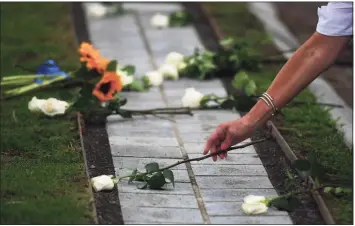  ?? Erik Trautmann / Hearst Connecticu­t Media ?? Friends and family of the victims lay roses on the outdoor memorial during the 2020 9/11 memorial ceremony Thursday at Sherwood Island State Park in Westport.