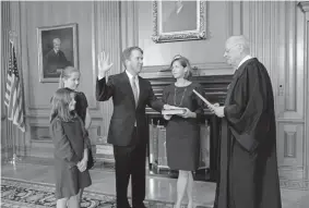  ?? Provided by U.S. Supreme Court via Getty Images ?? Justice Anthony Kennedy, who has retired, administer­s the judicial oath to newly confirmed Justice Brett Kavanaugh as Kavanaugh’s wife, Ashley, holds a Bible while joined by the couple’s daughters, Margaret and Liza, on Saturday night. The ceremony was in the Justices Conference Room at the U.S. Supreme Court Building in Washington. Kavanaugh, the 114th justice in U.S. Supreme Court history, is replacing Kennedy.