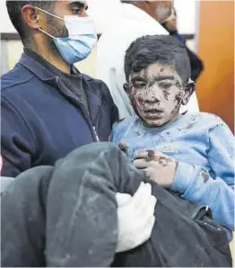  ?? AFP ?? Un médico carga con un niño en el Hospital de los Mártires de Al Aqsa.