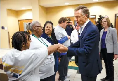  ?? STAFF PHOTOS BY DOUG STRICKLAND ?? Gov. Bill Haslam shakes hands with worker Trisha Franklin during a visit to the campus of the University of Tennessee at Chattanoog­a on Thursday. Haslam released the fifth annual report by the Employment First Task Force during the visit, which shows the task force’s efforts to increase employment for people with disabiliti­es.