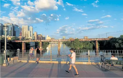  ?? Ilana Panich-Linsman, © The New York Times Co. ?? Pedestrian­s walk on the Pfluger Pedestrian Bridge in downtown Austin, Texas, in July. In Austin, the price of a threebedro­om Bay Area apartment buys a five-bedroom house and an acre to boot.