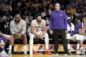  ?? AP file photo ?? Lakers coach Frank Vogel (from right) stands next to Anthony Davis and LeBron James on the bench during a game against the Nuggets on April 3. Vogel was fired Monday after the Lakers finished the season 33-49 and missed the 10-team Western Conference playoffs.