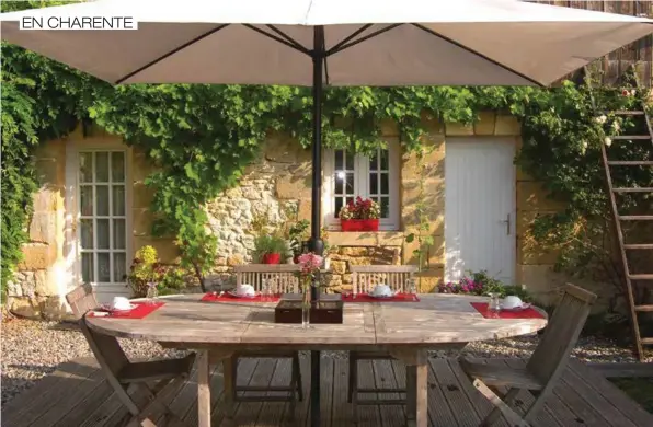  ??  ?? Le bois, élément essentiel de la table du petit-déjeuner en terrasse. Un côté rustique moderne qui donne encore plus de charme à la façade en pierres.