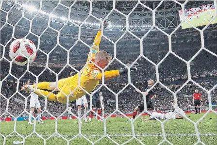  ?? FRANK AUGSTEIN THE ASSOCIATED PRESS ?? Croatia’s Ivan Perisic puts the ball past England goalkeeper Jordan Pickford to level the score in the second half of Wednesday’s World Cup semifinal.