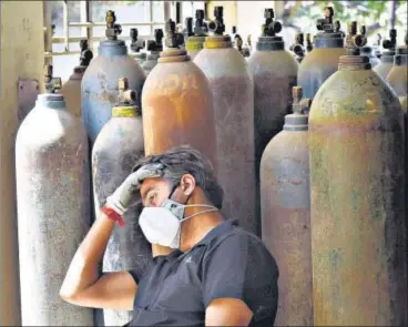  ??  ?? A relative of a Covid-19 patient waits to get a refill of a cylinder with medical oxygen in Badarpur on Sunday.