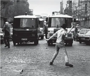  ?? Foto: imago/Peter Homann ?? Vermummte werfen am 1. Mai 1987 am Lausitzer Platz in Kreuzberg mit Steinen auf Polizisten.