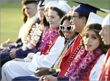  ?? PHOTOS BY JOEL ROSENBAUM — THE REPORTER ?? Wearing heart-shaped sunglasses, Vacaville Christian High School graduate Taleya Smith sits with her fellow members of the Class of 2022during commenceme­nt ceremonies Thursday at Vaca Christian. Taleya has attended the school since kindergart­en and was awarded a “Kindergart­ner to 12th Grade” award during the ceremony.
