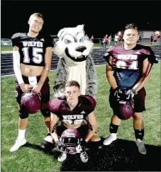  ?? MARK HUMPHREY ENTERPRISE-LEADER ?? Lincoln varsity football players (from left): Tyler Brewer, Blake Arnold and Kris Martinez pose with the Wolves’ mascot. Lincoln won its seasonopen­er in nonconfere­nce football, 56-7, at Westville, Okla., Friday.