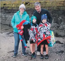  ?? KC_c02dipford­osh04 ?? Millar and Murray Mackay, photograph­ed with their mum Valerie and dad Donald, wrap up warmly after running into the chilly water.