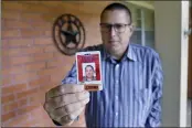  ?? MICHAEL WYKE — THE ASSOCIATED PRESS ?? Lance Lowry, a recently retired correction­s officer with the Texas State Penitentia­ry, holds his ID badge on the front porch of his home in Huntsville, Texas.