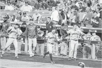  ?? Brett Coomer / Houston Chronicle ?? The Astros’ dugout erupts after Carlos Correa hit a solo home run in the 10th, but the Dodgers responded with two runs to send the game to the 11th, where George Springer’s homer won it.