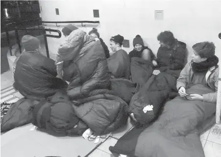  ??  ?? Central Middle School students rely on sleeping bags for warmth while spending the night just outside the Fort Street school.