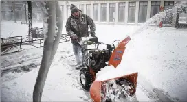  ?? BRIANA SANCHEZ / THE ARGUS LEADER ?? James Schoenhard plows sidewalks Saturday in downtown Sioux Falls, S.D. Huron, an eastern South Dakota city, received 18 inches of snow.