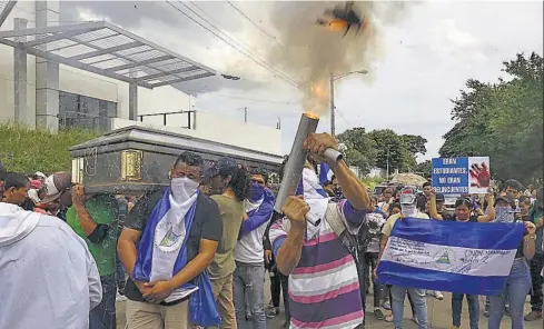  ??  ?? DESPEDIDA. FAMILIARES Y AMIGOS CARGAN EL ATAÚD CON EL CUERPO DE GERALD VÁSQUEZ, EL ESTUDIANTE DE INGENIERÍA ASESINADO EL VIERNES EN MEDIO DE UN ATAQUE DE POLICÍAS Y PARAMILITA­RES A LA UNAN, EN MANAGUA. LOS ESTUDIANTE­S SE VIERON EL VIERNES ACORRALADO­S POR HORAS POR LAS FUERZAS OFICIALIST­AS.