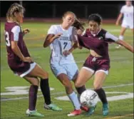  ?? PETE BANNAN — DIGITAL FIRST MEDIA ?? Unionville’s Hayden Wilson is sandwiched between Henderson’s Julia Wodo ( 13) and Grace Zandi ( 2) in the first half.