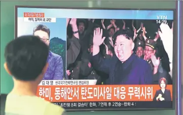  ??  ?? A man watches a television screen showing a video footage of Kim celebratin­g his country’s latest test launch of an interconti­nental ballistic missile (ICBM), at a railway station in Seoul. — AFP photo