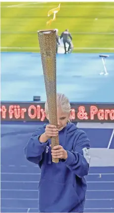  ?? FOTO: WOLFGANG KUMM/DPA ?? Ein Mädchen trägt die Olympische Flamme zum Jubiläum von „Jugend trainiert·für Olympia“. 2032 könnte Olympia in NRW stattfinde­n.