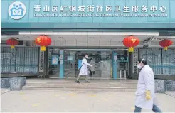  ??  ?? RIGHT A doctor disinfects the entrance of a community health service centre in the Qingshan district of Wuhan.
