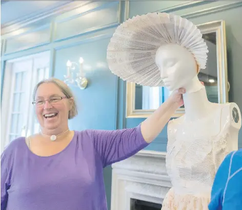  ?? PHOTOS: MICHAEL BELL ?? Caitlin Malone, a member of the Jane Austen Book Club, holds up a mannequin head with a bonnet made of paper that is part of an ensemble, including a paper dress, that the club is creating from the author’s letters. The dress will be displayed during...