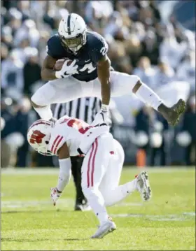  ?? ABBY DREY — CENTRE DAILY TIMES VIA AP ?? Penn State running back Miles Sanders hurdles Wisconsin’s Faion Hicks during an NCAA college football game Saturday in State College, Pa.