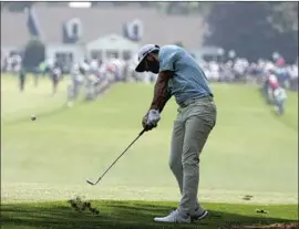  ?? Charlie Riedel Associated Press ?? DEFENDING CHAMPION Dustin Johnson hits on the first fairway during a practice round for the Masters golf tournament in Augusta, Ga.