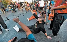  ?? CHRIS SWEDA/CHICAGO TRIBUNE ?? Pfleger sits in the street at Racine and 79th Street on Sept. 23 during a protest against the announceme­nt of charges in the Breonna Taylor case.