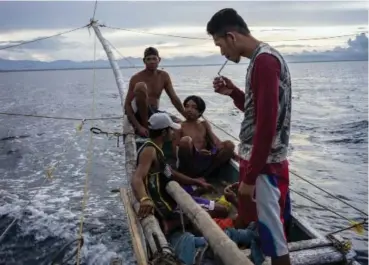  ??  ?? A fishing boat’s crew heads out from Kalibo, the Philippine­s. More than a quarter of Filipinos smoke, according to a 2015 World Health Organisati­on report, including 11 percent of minors.