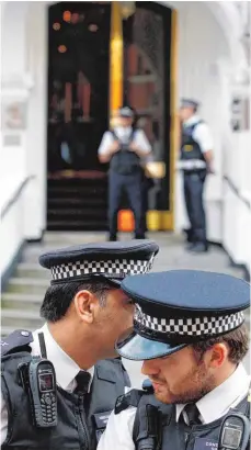 ?? FOTO: DPA ?? Polizisten bewachen rund um die Uhr die Botschaft Ecuadors in London. Sie sollen Assange beim Verlassen des Gebäudes festnehmen.