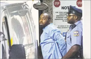  ?? Elizabeth Robertson / Associated Press ?? Police take shooting suspect Maurice Hill into custody after an hourslong standoff with police, that wounded six police officers, in Philadelph­ia early Thursday.