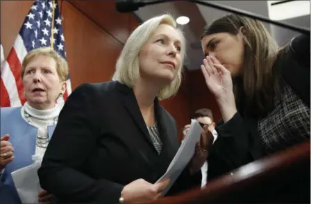  ?? JACQUELYN MARTIN — THE ASSOCIATED PRESS ?? Sen. Kirsten Gillibrand, D-N.Y., center, listens to a staffer before answering questions at a news conference, Tuesday on Capitol Hill in Washington. Gillibrand says President Donald Trump’s latest tweet about her was a “sexist smear” aimed at...