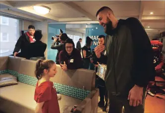  ?? STEVE RUSSELL TORONTO STAR ?? Abby Dangerfiel­d gives Jonas Valanciuna­s a hand clap as The Toronto Raptors make their annual team visit to the Hospital for Sick Children in Toronto on Thursday.