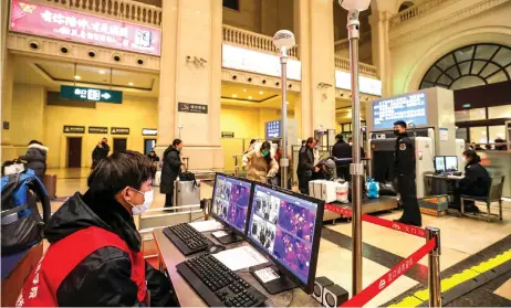  ?? — AFP photo ?? A staff member screens arriving passengers with thermal scanners at Hankou railway station in Wuhan, in China’s central Hubei province.