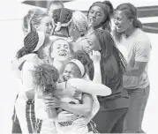  ?? Tim Warner ?? Tournament MVP Maya Hawkins, center, gets a hug from Rice’s Jasmine Goodwine as the Owls celebrate winning the Women’s Basketball Invitation­al title.