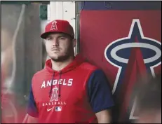  ?? Associated Press ?? The Angels’ Mike Trout stands in the dugout before the team’s game against the Texas Rangers on Saturday in Anaheim. Trout is nearing a return after finding out he has a rare spinal condition.