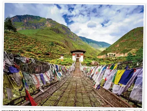  ?? Photo: iStock ?? WALK THIS WAY: A prayer flag decorated suspension bridge over a river on the route between Paro and Thimphu, Bhutan.