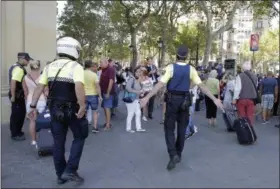  ?? PHOTOS BY MANU FERNANDEZ — THE ASSOCIATED PRESS ?? Police officers tell members of the public to leave the scene in a street in Barcelona, Spain, Thursday.