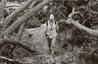  ?? Gabe Hernandez / Corpus Christi Caller-Times ?? Julie Garcia walks through flood devastatio­n in Wimberley while reporting on the disaster in May 2015.