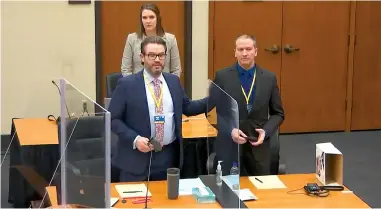  ?? The Associated Press ?? Q In this screen grab from video, defense attorney Eric Nelson, left, defendant and former Minneapoli­s police officer Derek Chauvin, right, and Nelson’s assistant Amy Voss, back, introduce themselves to potential jurors as Hennepin County Judge Peter Cahill Tuesday presides over jury selection in the trial of Chauvin at the Hennepin County Courthouse in Minneapoli­s, Minn. Chauvin is charged in the May 25, 2020, death of George Floyd.